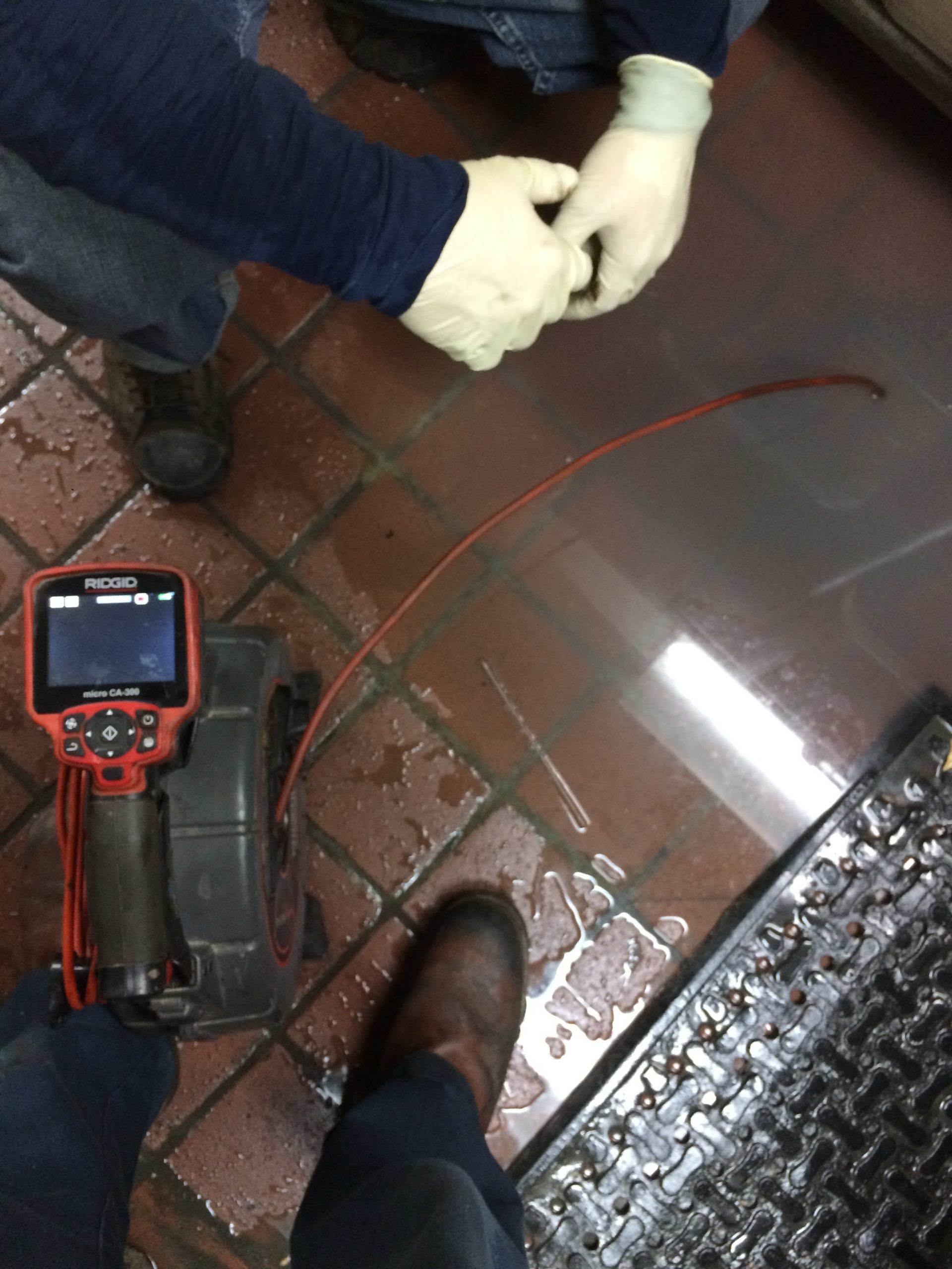 Certified technician performing grease trap cleaning in an Irwindale commercial kitchen